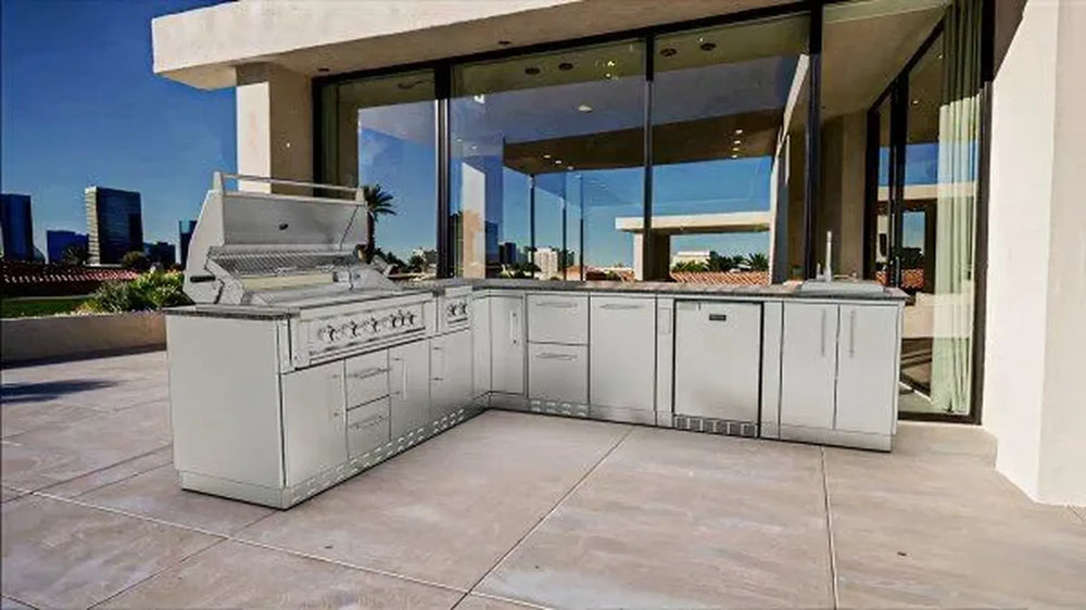 Modern patio installation of Sunstone SCPRANCHER8.10BY11 Rancher L-shaped island with gas grill, sink, and stainless outdoor cabinets.