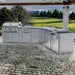 Outdoor lifestyle shot of the Sunstone Savanna 16ft stainless steel kitchen island on a cobblestone patio overlooking a lawn.