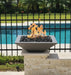 Grey Travertine TessaRai 36 inch Square Fire Bowl Kit with lava rock flames mounted on pool wall pedestal