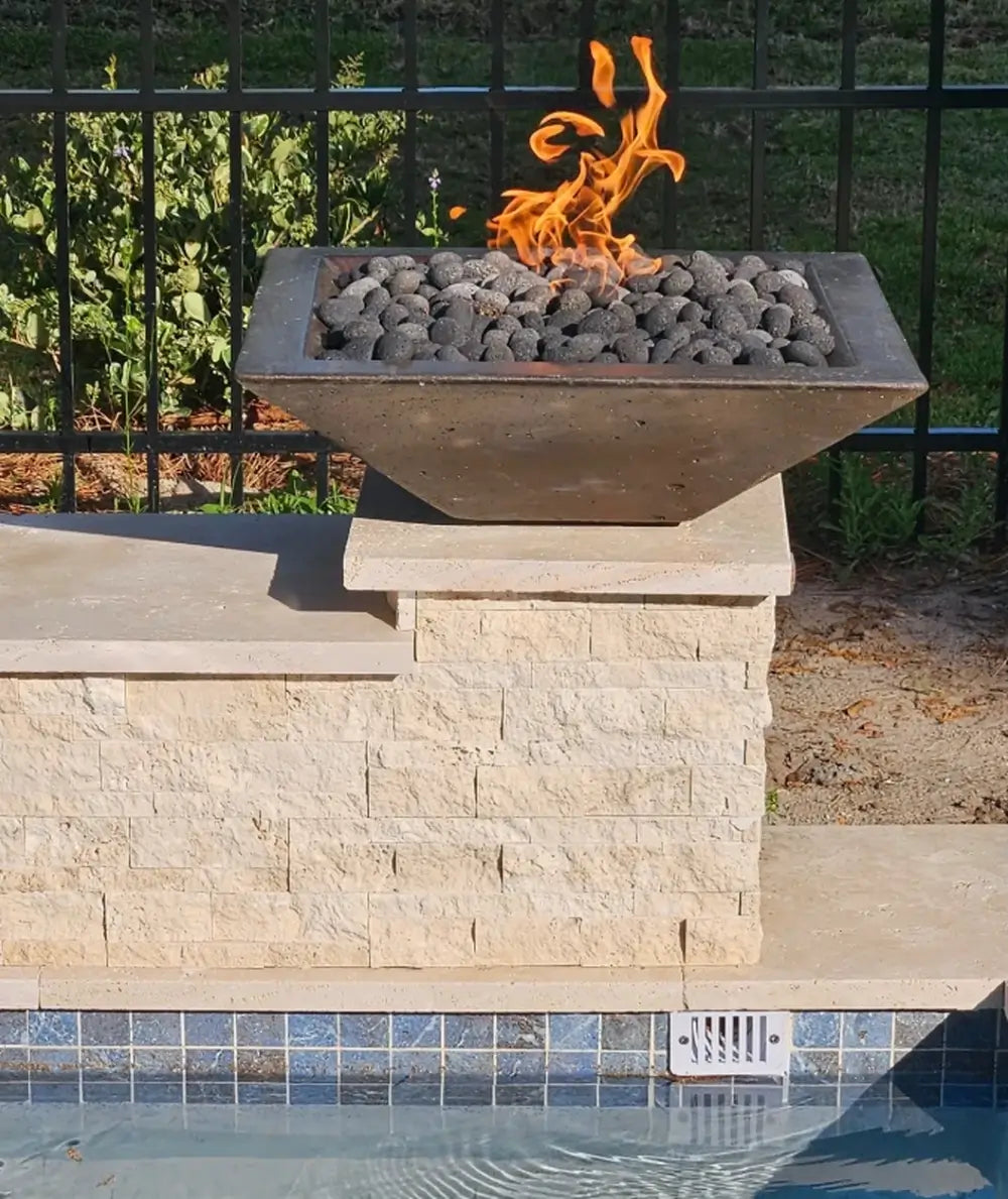 Travertine TessaRai 36 inch Square Fire Bowl Kit close-up with lava rock fire feature on stacked stone pool pedestal