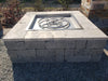 TessaRai square gas fire pit kit under construction featuring a grey stone block base and light travertine top caps with a stainless steel burner insert.