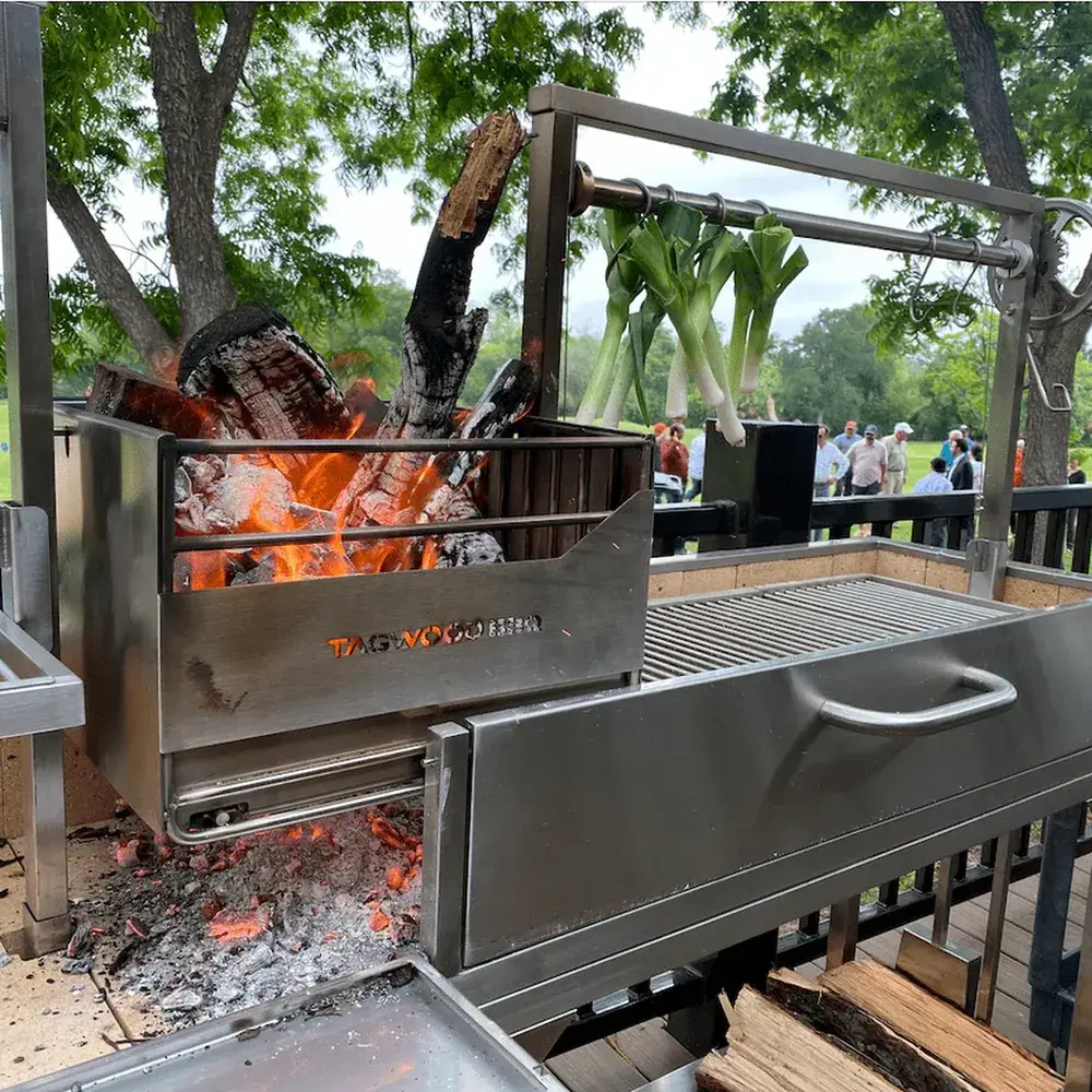 Tagwood BBQ04SS Double Santa Maria grill wood fire charcoal basket with burning logs close up