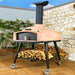WPPO Red Rock 100 outdoor wood-fired stone oven on patio with firewood storage, chimney, caster wheels, and peach dome.