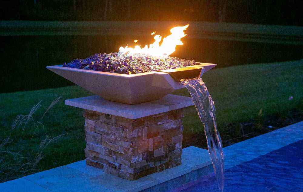 Travertine TessaRai Square Fire/Water Bowl Kit with blue fire glass, flames and waterfall spillway at night