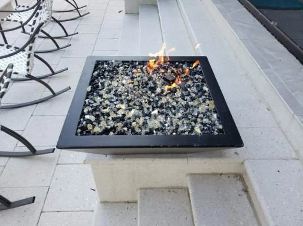 Travertine TessaRai 36 inch Square Fire Bowl Kit with black and clear fire glass on sleek raised poolside platform