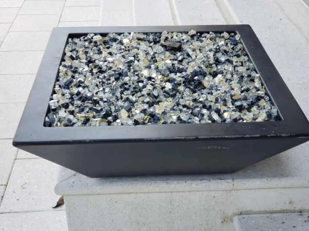 Travertine TessaRai 36 inch Square Fire Bowl Kit filled with reflective fire glass on modern white pool ledge