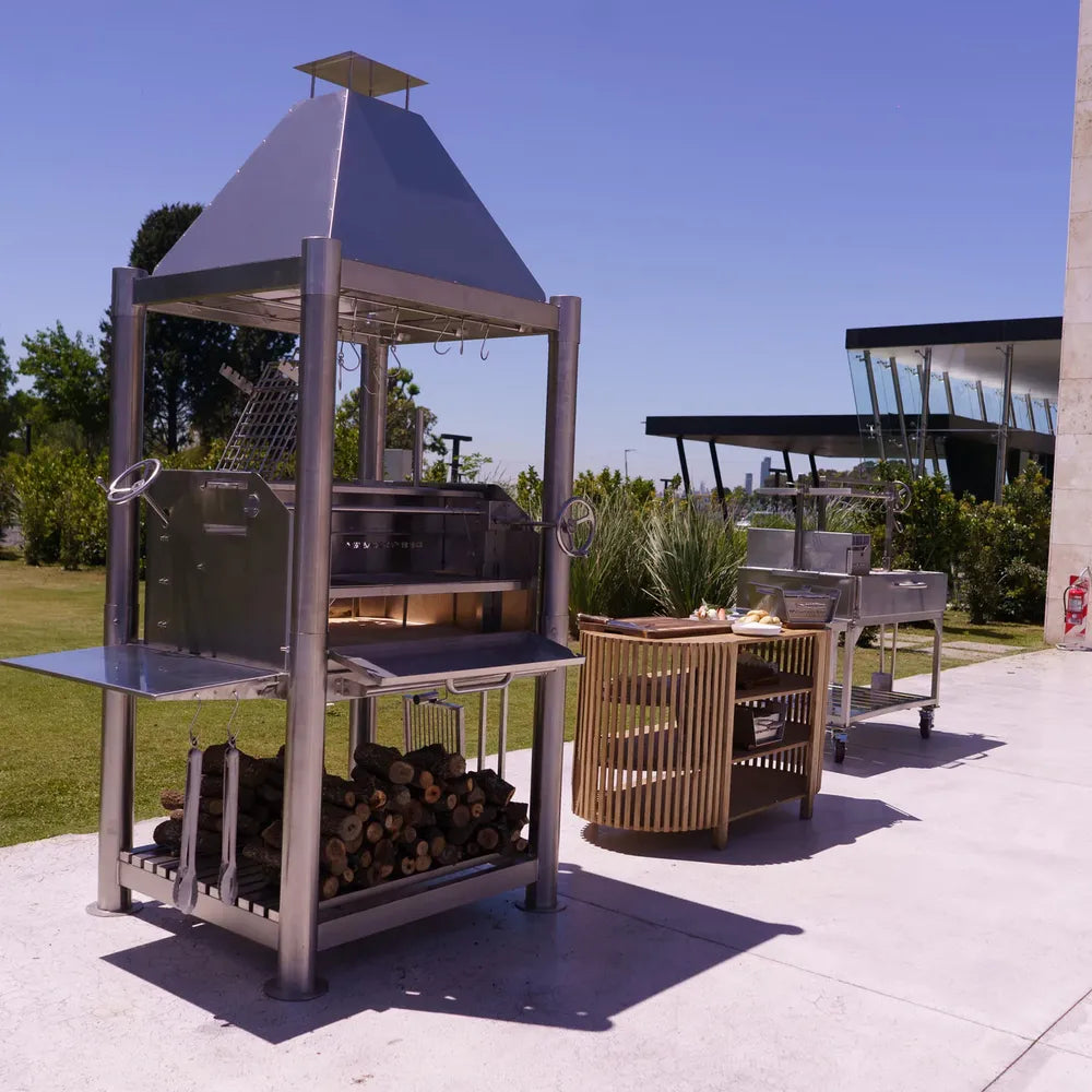 Tagwood BBQ BBQ02SS Santa Maria grill angled view with prep cart and wood storage