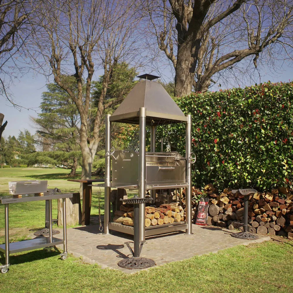 Tagwood BBQ BBQ02SS Santa Maria Grill SS304 in backyard with firewood storage and prep table