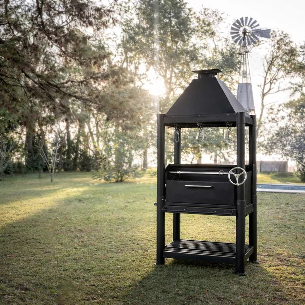 Tagwood BBQ BBQ12SI Santa Maria grill with chimney and lower log storage in backyard
