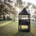 Tagwood BBQ BBQ12SI Santa Maria grill with chimney and lower log storage in backyard