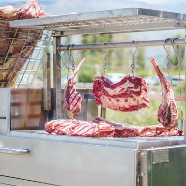 Tagwood BBQ26SS XL Santa Maria grill hanging raw beef cuts on hooks above cooking grates