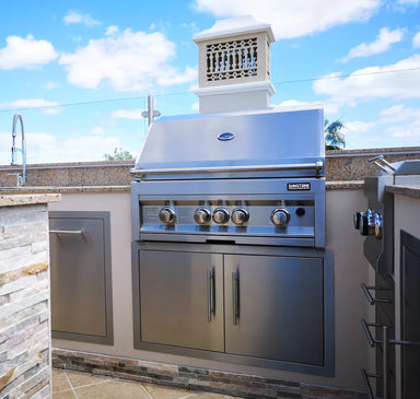Sunstone 36" stainless double access doors installed below built-in gas grill in outdoor kitchen island with stone countertop.