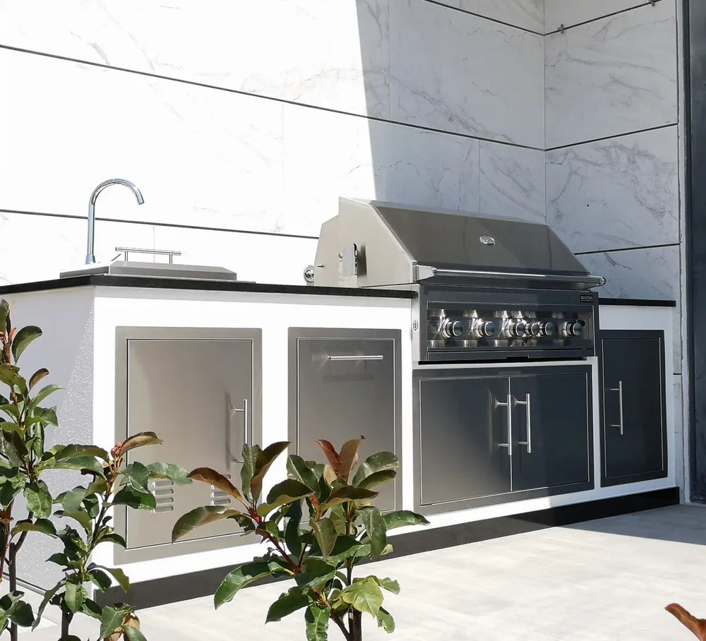 Sunstone 36" vented stainless double access doors installed in outdoor kitchen island with built-in grill, sink, and stone countertop.