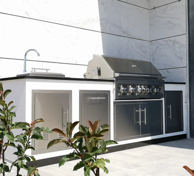 Sunstone 36" vented stainless double access doors installed in outdoor kitchen island with built-in grill, sink, and stone countertop.