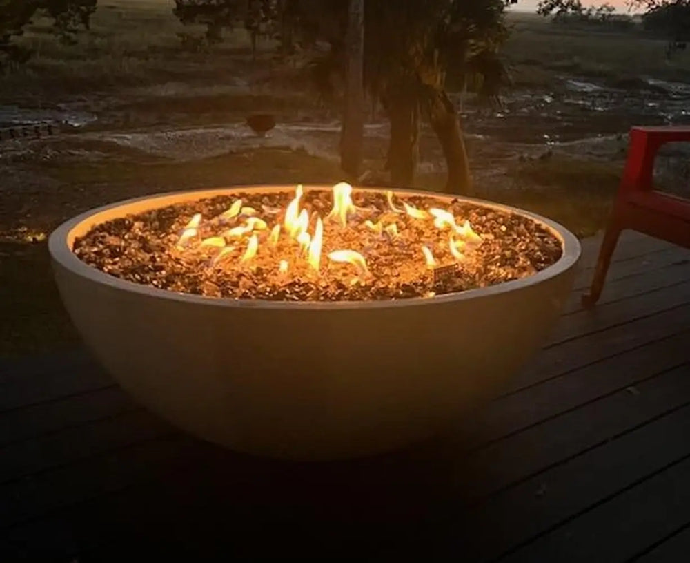 Travertine TessaRai 40 inch Patio Fire Pit Kit with wide circular flame display on elevated deck near marsh landscape