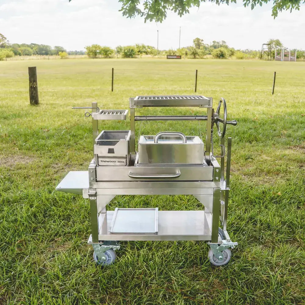 Tagwood BBQ03SS Mini Santa Maria grill with lid accessory on grassy field outdoor setting