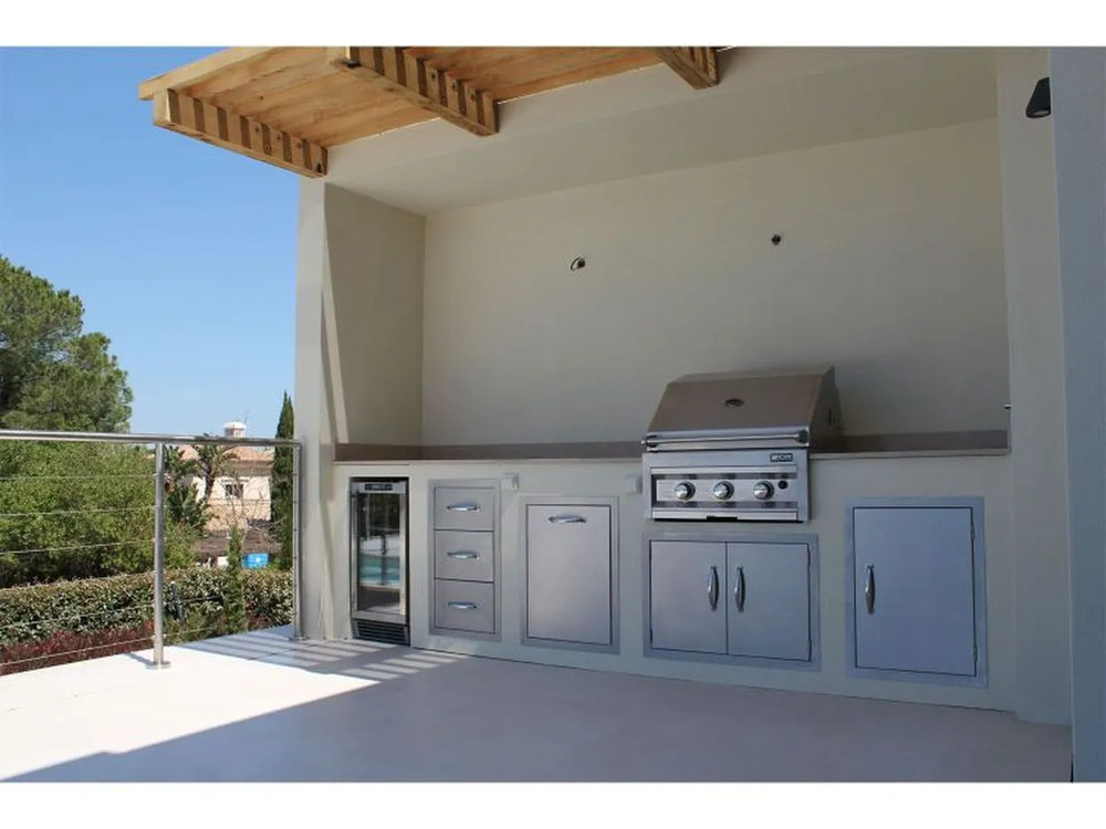 Built-in outdoor kitchen with stainless grill, fridge, drawers, and Sunstone storage access doors under a covered patio counter.