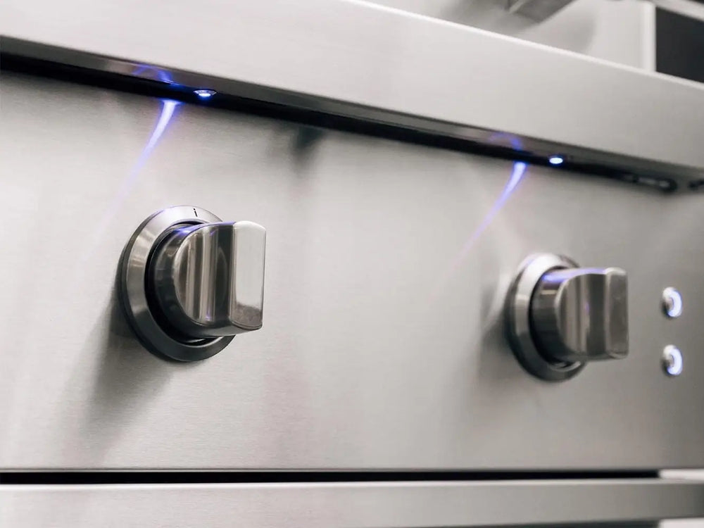Close-up of precision control knobs with blue LED lights on premium stainless steel gas grill.