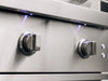 Close-up of precision control knobs with blue LED lights on premium stainless steel gas grill.