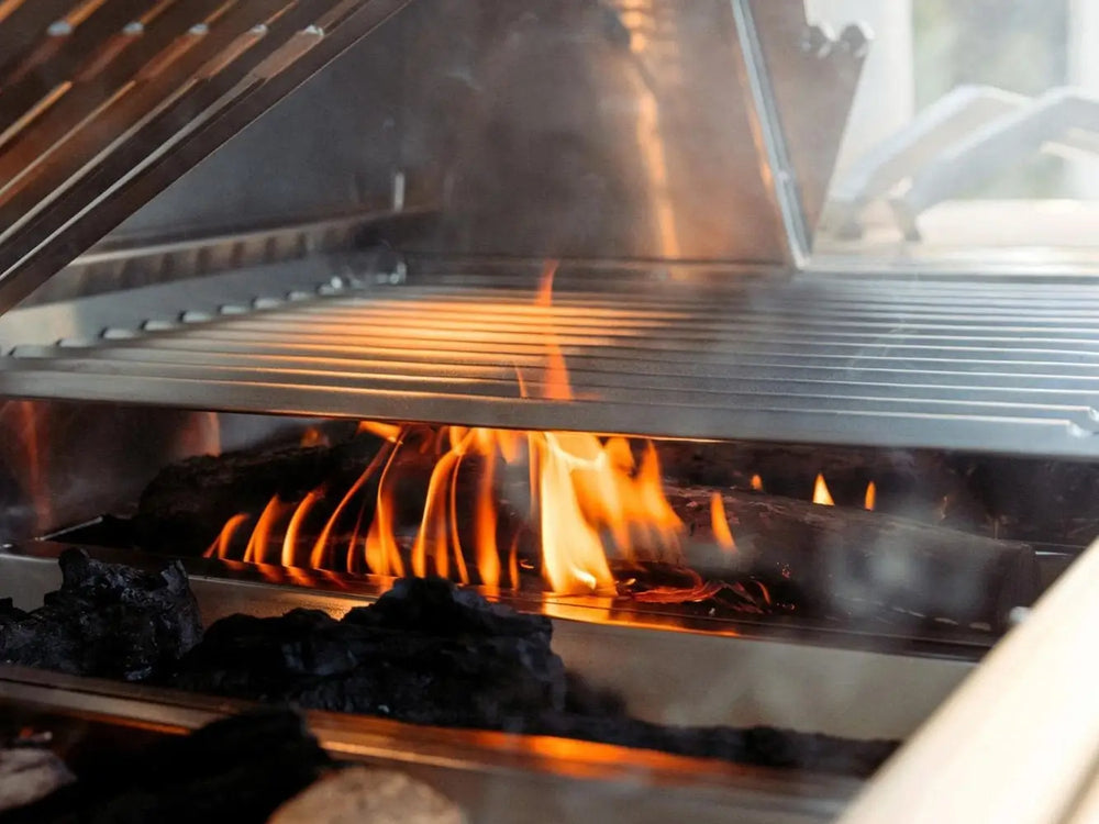 Close-up of flames under stainless steel cooking grates in luxury outdoor grill