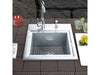 Sunstone B-PS21 sink installed in outdoor countertop with faucet, bottom grid and cutting board cover, ideal for patio kitchen prep.