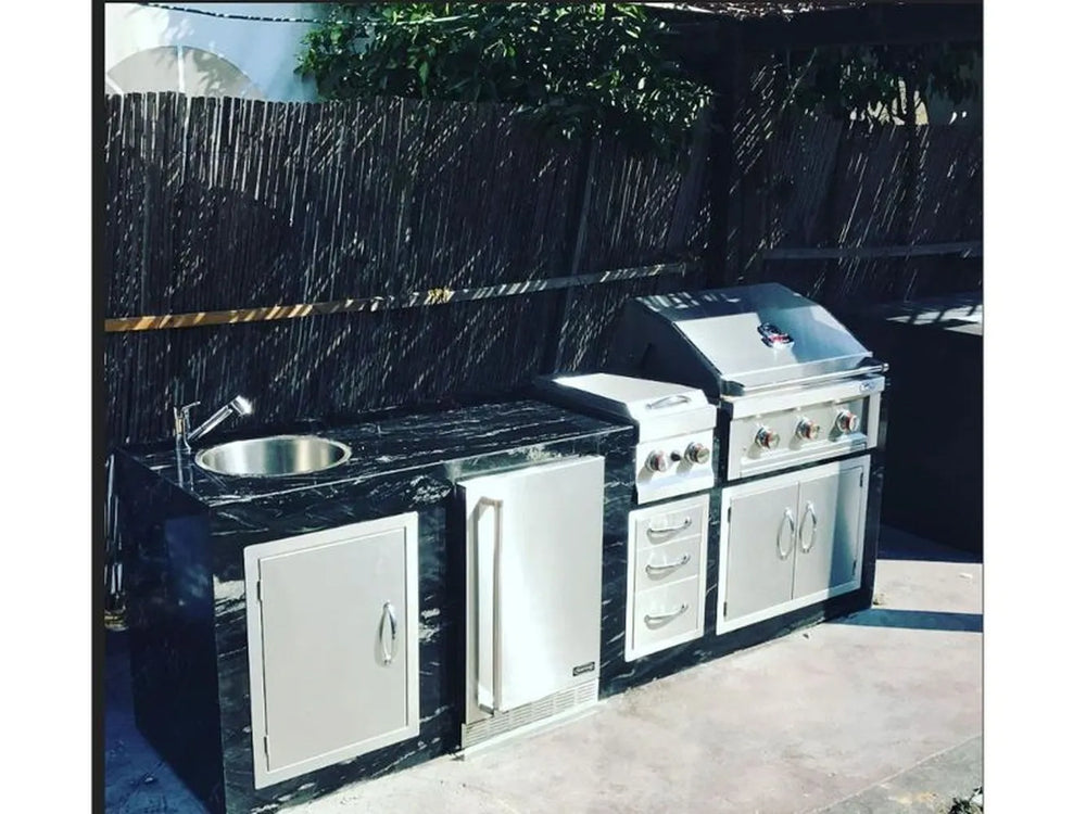 Shows the 3-drawer stack installed in an outdoor kitchen island (between the fridge and the grill doors).
