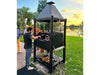 Tagwood BBQ BBQ02SIB Santa Maria grill in backyard setting with open fire cooking at sunset