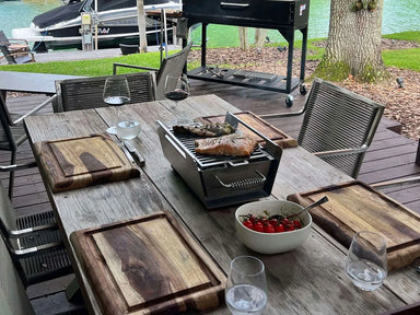 Tagwood BBQ07SS tabletop brazier food warmer grilling steak and vegetables on outdoor dining table by waterfront