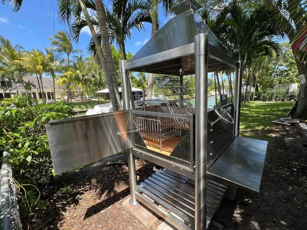 Tagwood BBQ BBQ12SS Argentine grill angled backyard view with chimney hood