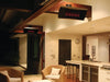 Two Bromic Platinum 500 Gas Radiant Heaters mounted on the ceiling of a stylish indoor-outdoor living space, providing warmth to the seating area near the kitchen.