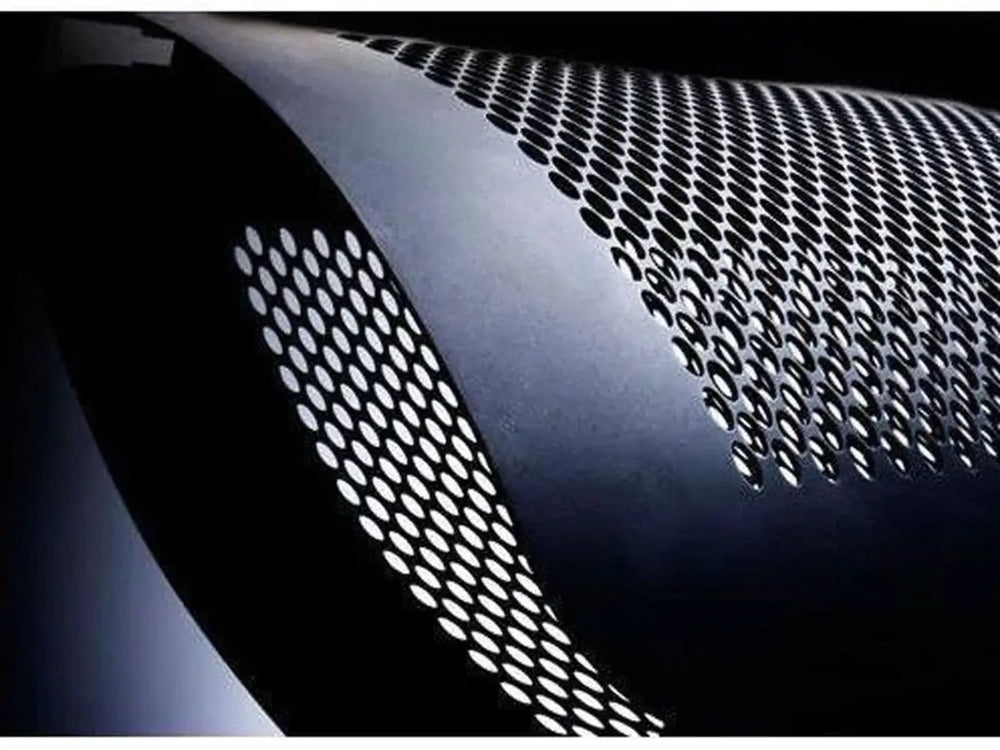A detailed, artistic shot of the curved, perforated metal housing on the Bromic Tungsten 300 Gas Radiant Heater.
