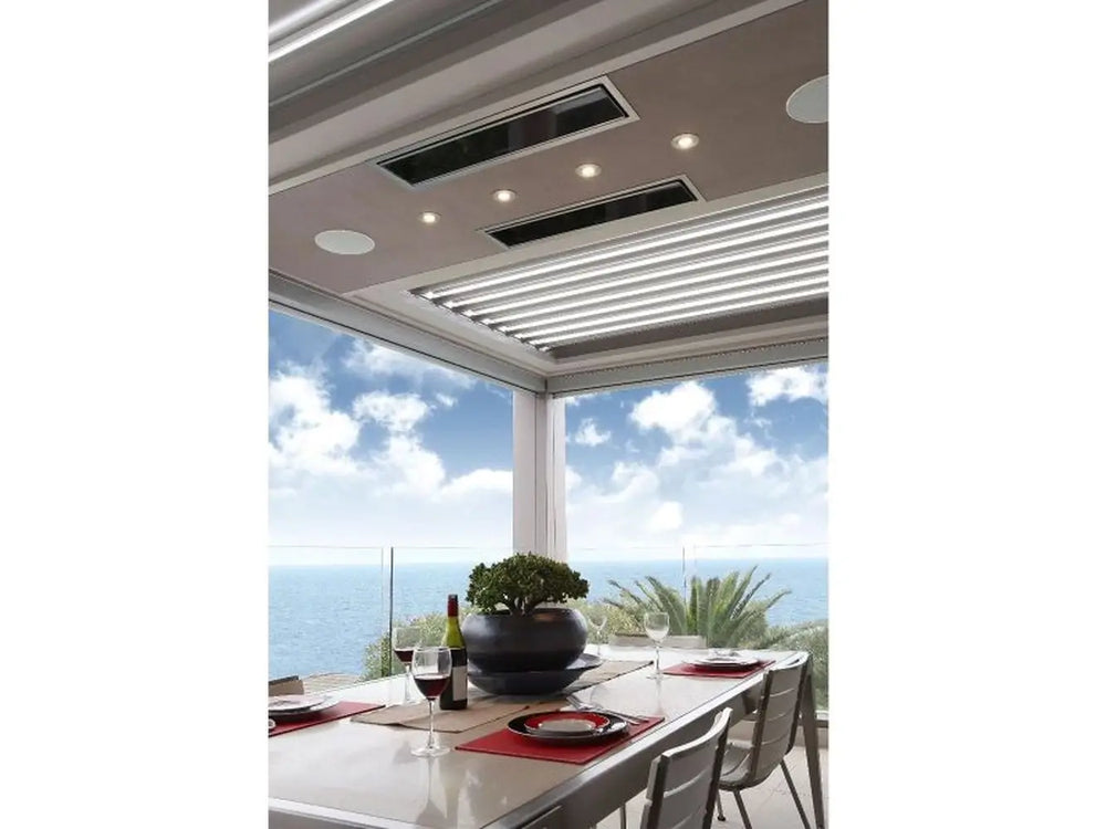 Two white Bromic Platinum Electric Heaters recessed into the ceiling of a modern patio with an ocean view.