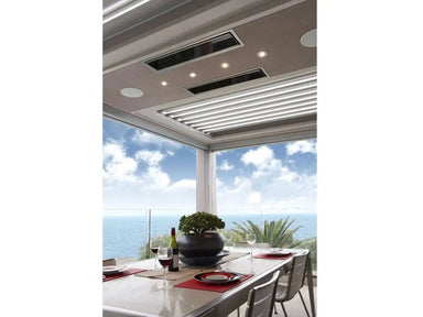 Two white Bromic Platinum Electric Heaters recessed into the ceiling of a modern patio with an ocean view.
