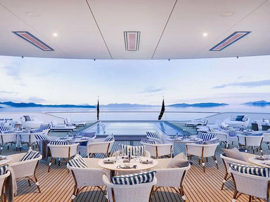 Luxury yacht deck with Bromic Platinum 3400W Electric Infrared Heaters installed in the ceiling, providing sleek, discreet heating for an elegant alfresco dining space overlooking the sea.