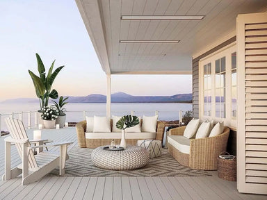 Bromic Platinum 3400W Electric Infrared Heaters mounted on a covered patio ceiling, seamlessly blending with the modern coastal decor featuring wicker seating, ocean views, and neutral tones.