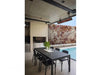 Black Bromic Tungsten 6000W Infrared Heater mounted above a sleek outdoor dining space near a pool, complementing a minimalist contemporary design.