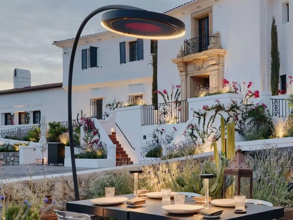 Bromic Eclipse black portable electric heater with curved stand on a stylish outdoor patio in a luxury residence.
