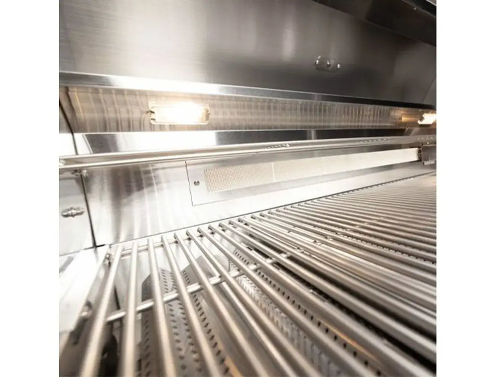 Grill interior with stainless steel cooking grates, built-in lights, and lit rear infrared ceramic burner.