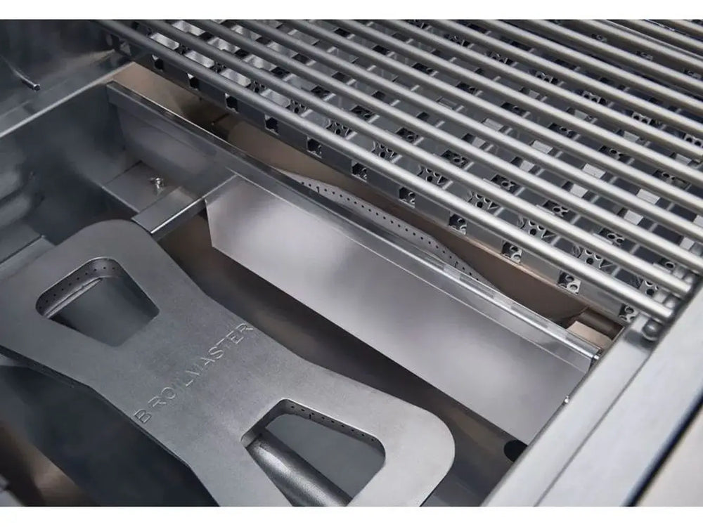 Stainless steel cooking grates lifted to show the Broilmaster labeled main burner and heat plate.