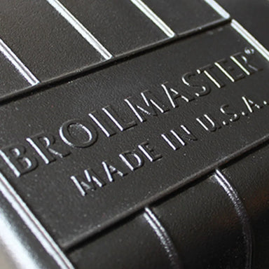 Close-up detail of the Broilmaster logo and 'Made in U.S.A.' text on the premium cast aluminum grill hood