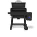 Broil King Crown Pellet 500 WiFi pellet smoker with lid open, showing the spacious pellet grill interior, upper warming rack, digital temperature display on the side hopper, compact front shelf, and sturdy black cart base with wheels.