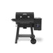 Front view of the Broil King Crown Pellet 400 WiFi pellet smoker in matte black, featuring a rounded barrel body, chrome handle, side-mounted pellet hopper with digital temperature display, compact side shelf, sturdy tubular legs, and transport wheels.