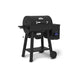Angled front-left product shot of the Broil King Crown Pellet 400 WiFi pellet smoker, showing the closed barrel lid, chrome handle, side shelf, pellet hopper with digital screen, lower support shelf, and rolling wheel design.