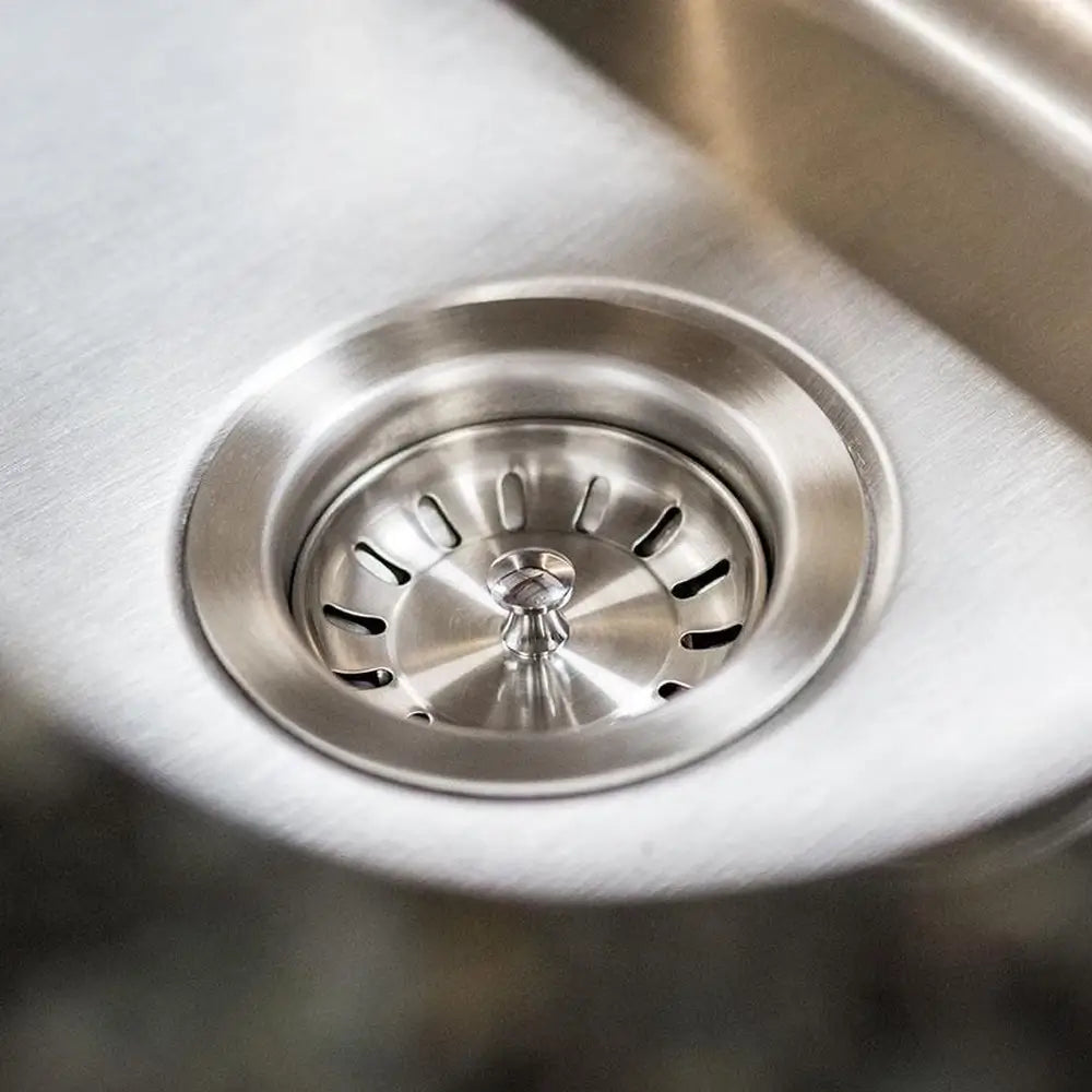 Close-up of the Summerset SNK-19U stainless steel sink drain and strainer basket.