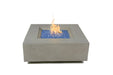 60,000 BTU Capertee fire table with linear flame and lava rocks on white background.