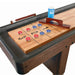 Close-up of a wooden shuffleboard playfield with scoring numbers, red and blue pucks, a wooden scoring abacus, and a wax applicator. (Alternative style for comparison).