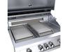 Two Sunstone stainless griddle inserts positioned inside a gas grill, demonstrating recessed placement alongside grill grates.