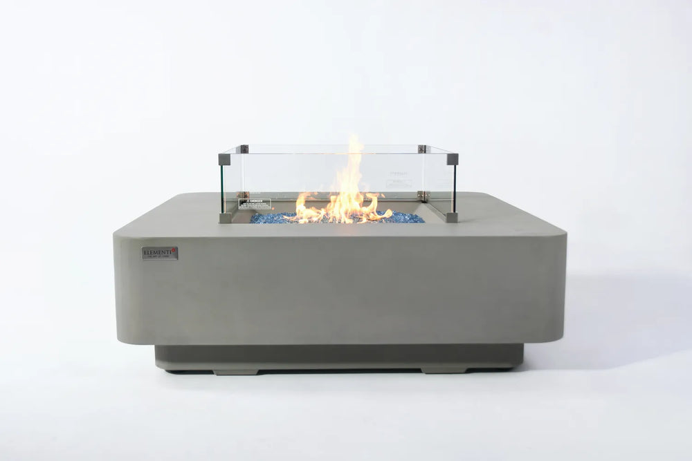 Elementi Plus Lucerne OFG419LG light gray fire table with glass wind guard and blue fire glass.
