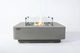 Elementi Plus Lucerne OFG419LG light gray fire table with glass wind guard and blue fire glass.