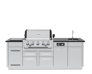 A direct front view of the fully assembled Broil King Imperial QS 590iE Smart Grill Island on a pure white background, showcasing the central built-in gas grill, control panel, sink, and side cabinets.
